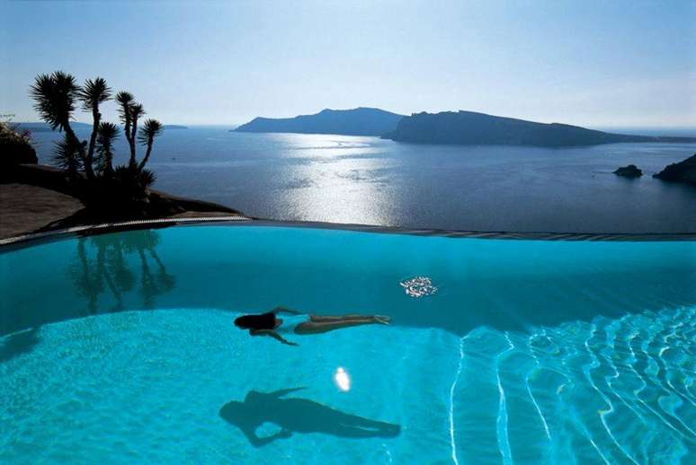 Perivolas Santorini, Grécia. Situado no topo de uma falésia da ilha de Santorini, o hotel Perivolas oferece conforto, luxo, e um maravilhoso visual a seus hóspedes. A piscina de borda infinita dá uma vista panorâmica do mar e das montanhas, num cenário único para aproveitar o sol grego